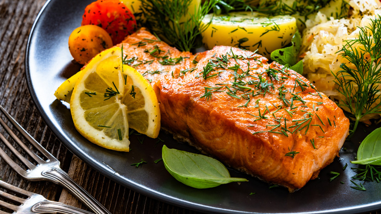 A salmon fillet garnished with herbs.