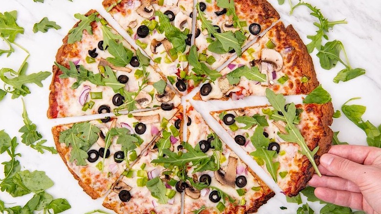 Gluten-free cauliflower pizza with veg and arugula
