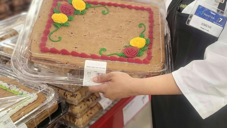 A woman holds up a custom cookie cake at Sam's Club