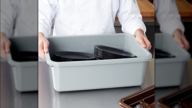 A Cambro bus tub with plates inside