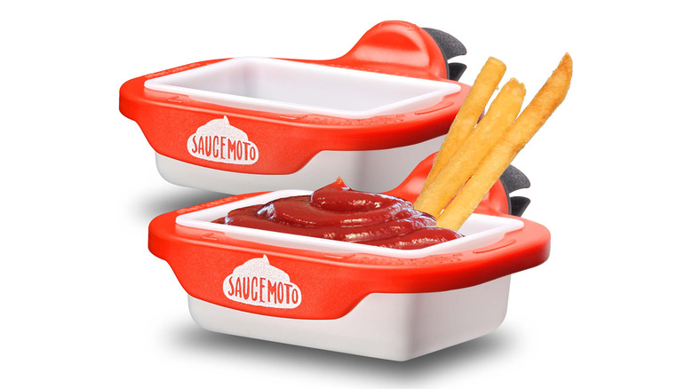 Two Saucemoto dip clip containers holding ketchup and french fries