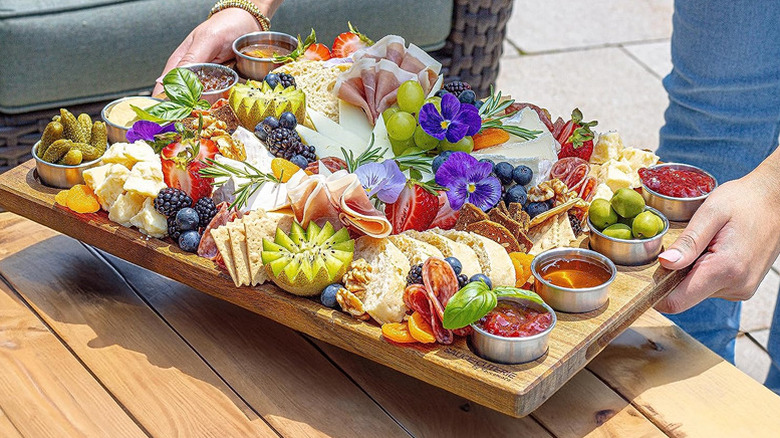 Sauce-Cuteries wood charcuterie board with meat, cheese, fruit, flowers