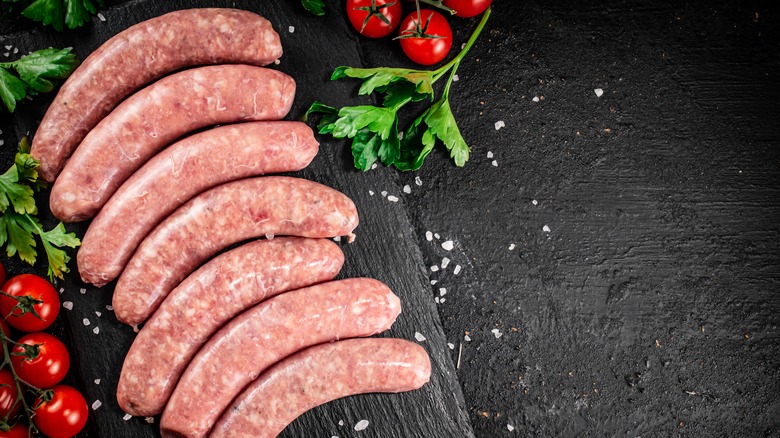 raw sausages on black slate