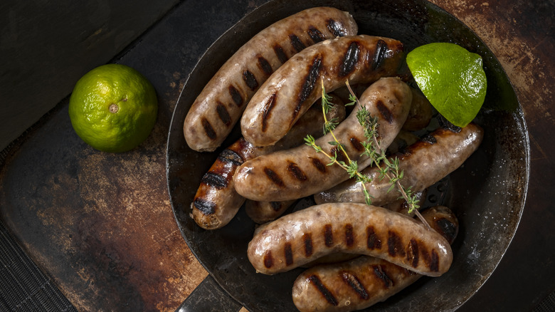 sausages in pan with limes