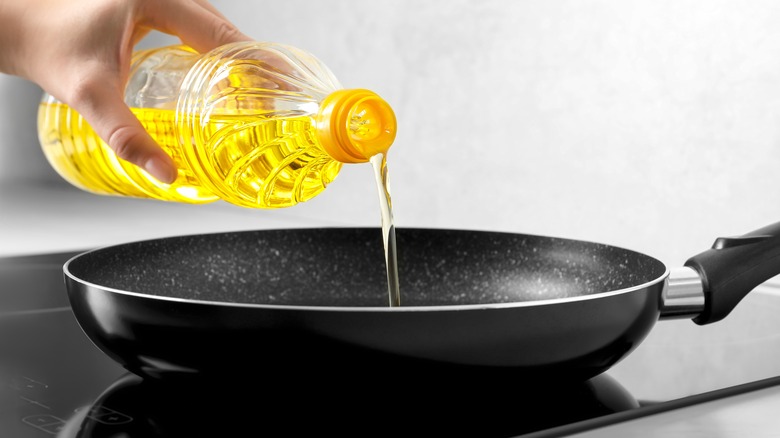 pouring oil into frying pan