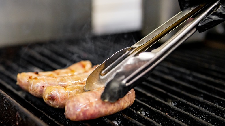 turning sausages with tongs