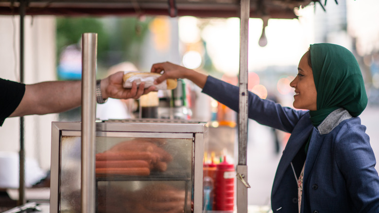 woman buying a hot dog