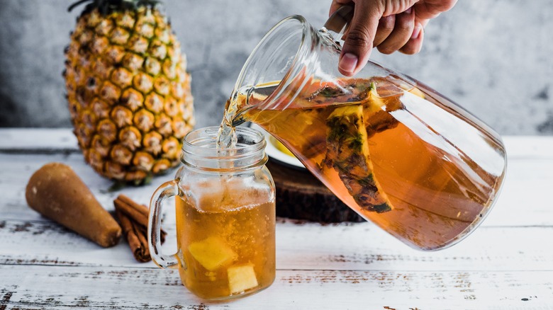 pouring pineapple tea drink into glass