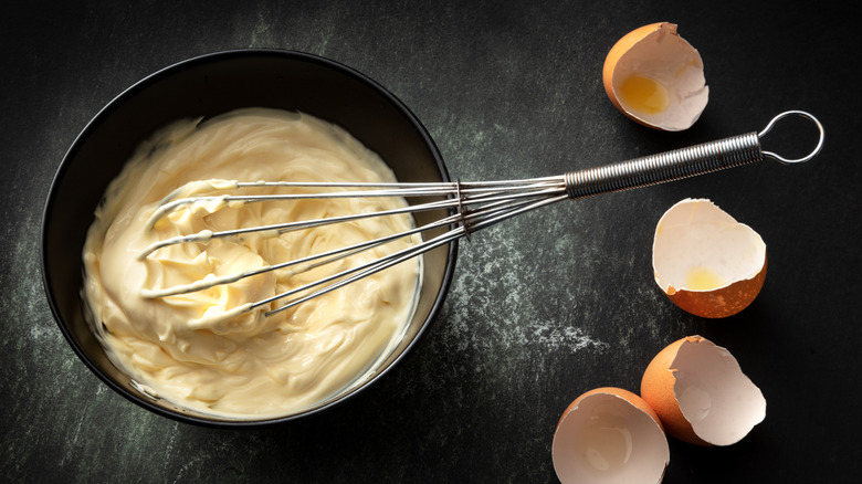 Bowl of mayo and whisk with egg shells
