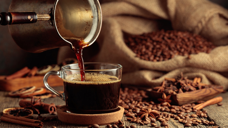 Pouring a cup of coffee from a Turkish coffee pot