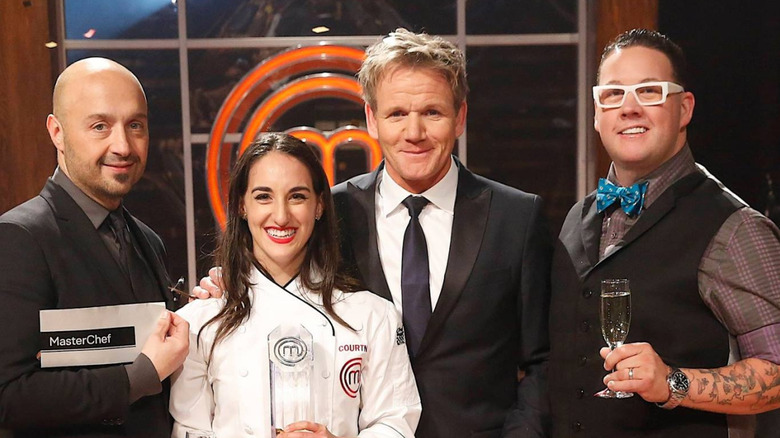 winner of season 5 MasterChef posing with judges