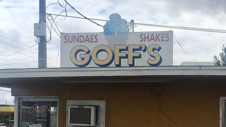 Yellow, white, blue, and red Goff's Drive In sign on the roof of a yellow building
