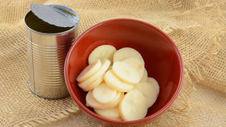 Canned potatoes sit in a red bowl.