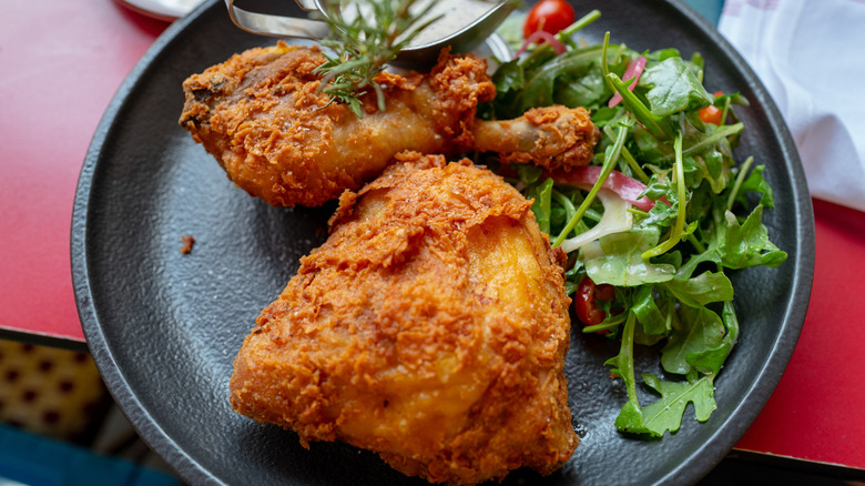 Crispy fried chicken next to a side salad