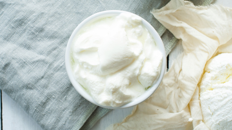 Dairy product in a white ramekin on a blue dish towel.