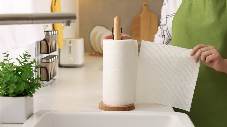 cook tearing paper towel off roll in kitchen