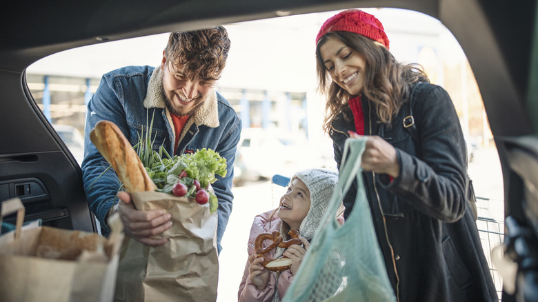 family loading groceries into their car