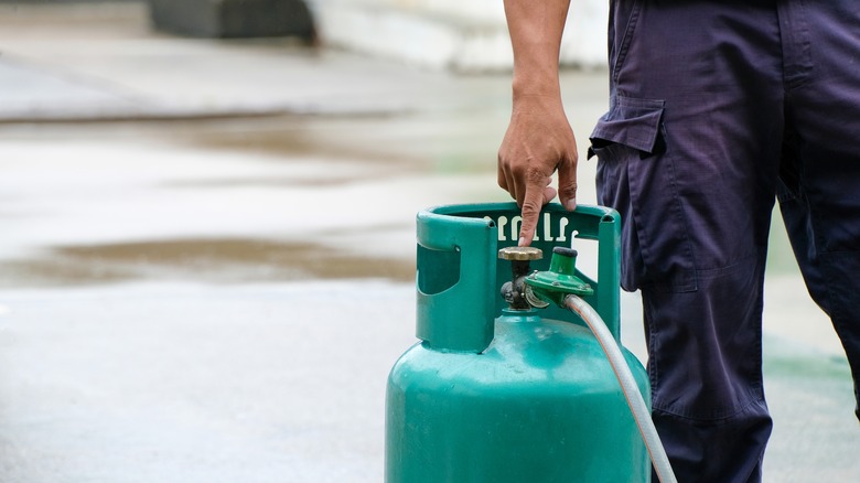 Person holding propane tank