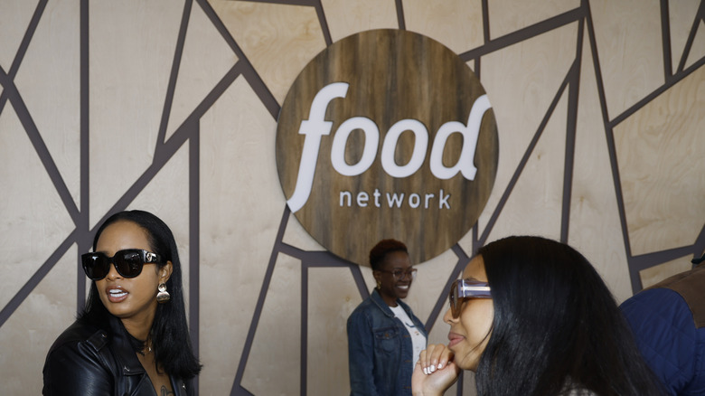 A Food Network sign hangs on the wall at a publicity event