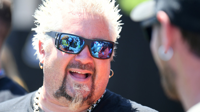 Closeup of chef Guy Fieri wearing sunglasses at an outdoor event