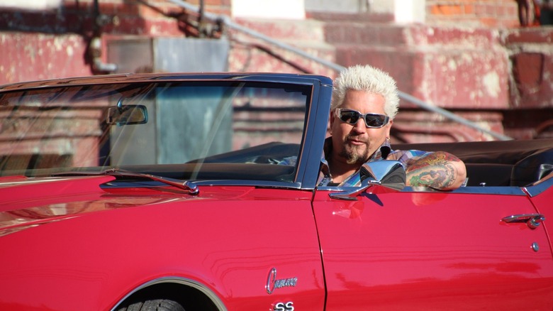 Celebrity chef Guy Fieri in a red car