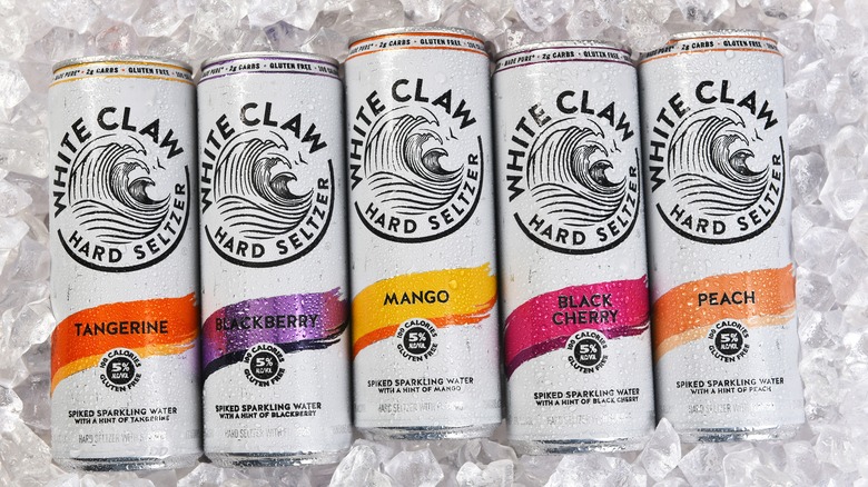 Various White Claw hard seltzer cans on a bed of ice