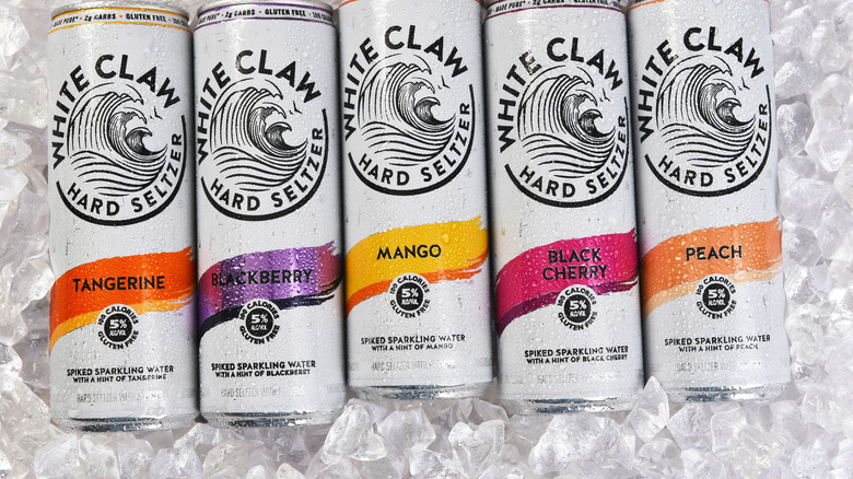 Various White Claw hard seltzer cans on a bed of ice