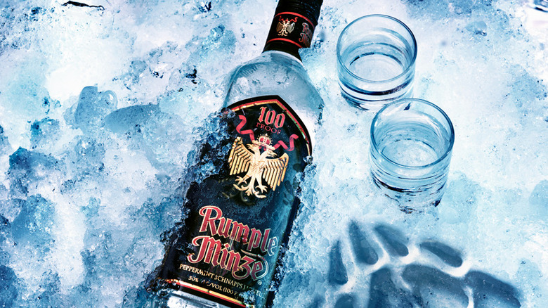 Bottle of Rumple Minze on ice with two shot glasses