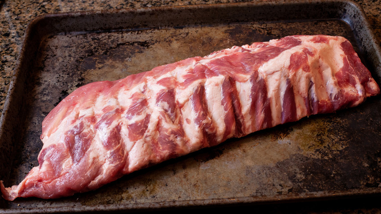 Raw baby back ribs on an oven sheet