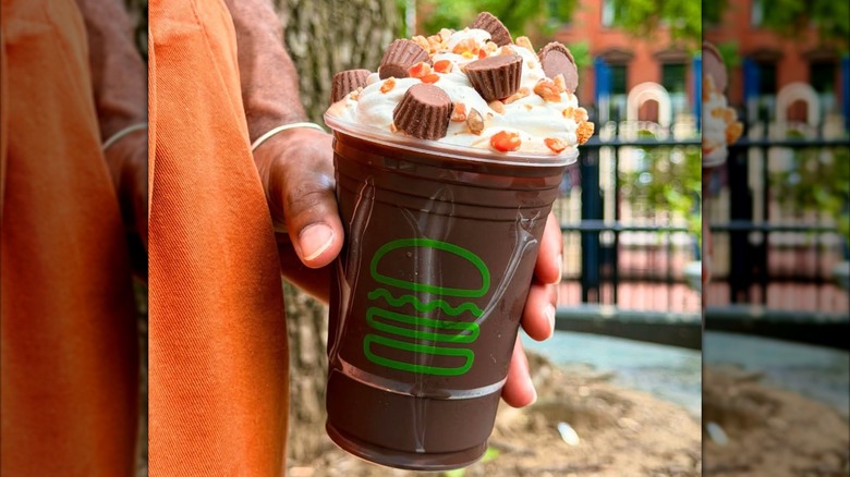 Someone holds Shake Shack's Reese's Shake.