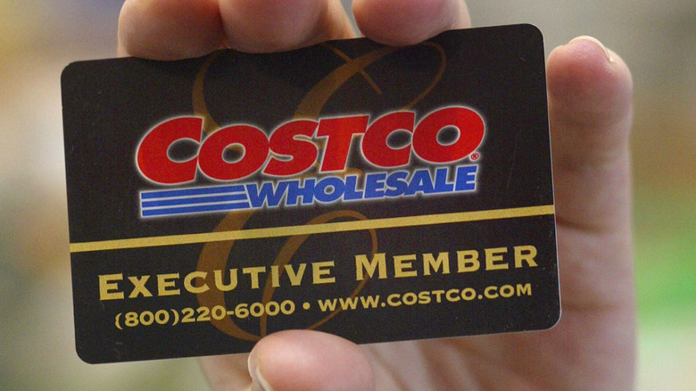 A member holds their Costco Executive Membership card close to the camera