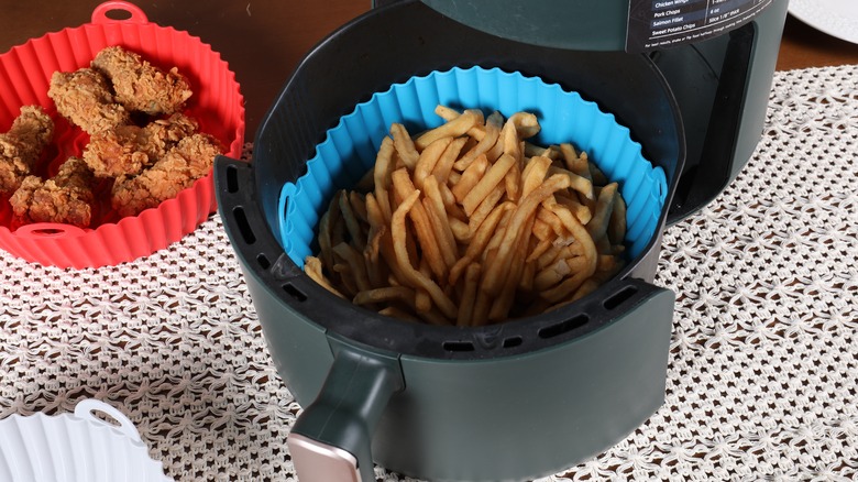 Air fryer with blue liner holding french fries