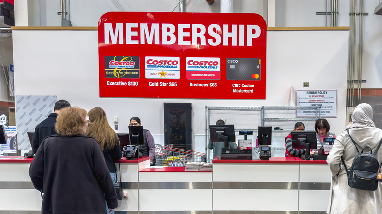 Customer service counter inside Costco with a large membership sign hanging overhead