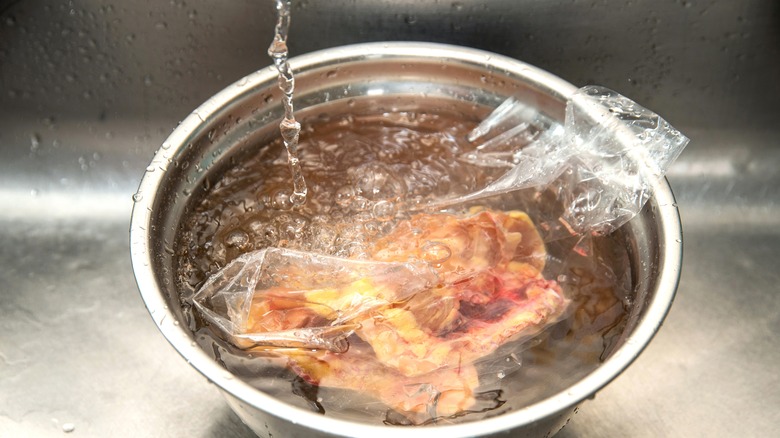 Defrosting chicken in a bowl of water