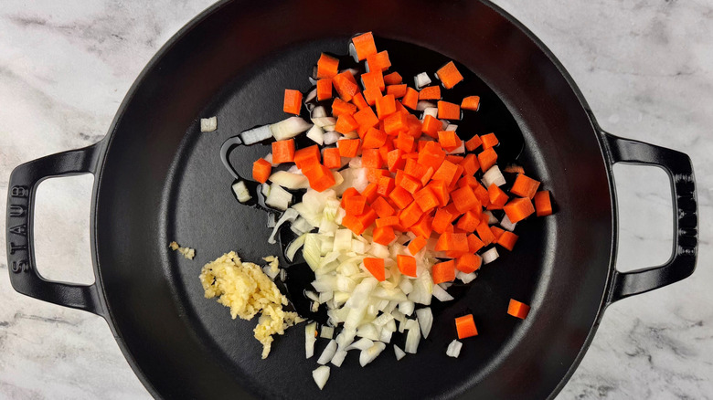 Diced carrots, onion, and garlic in pan