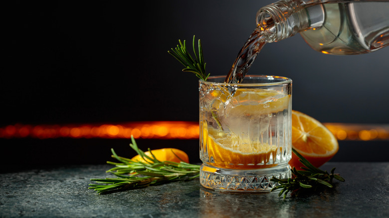 A gin and tonic with herbs and citrus.