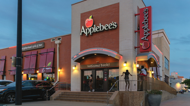 Exterior of an Applebee's with a handful of people outside