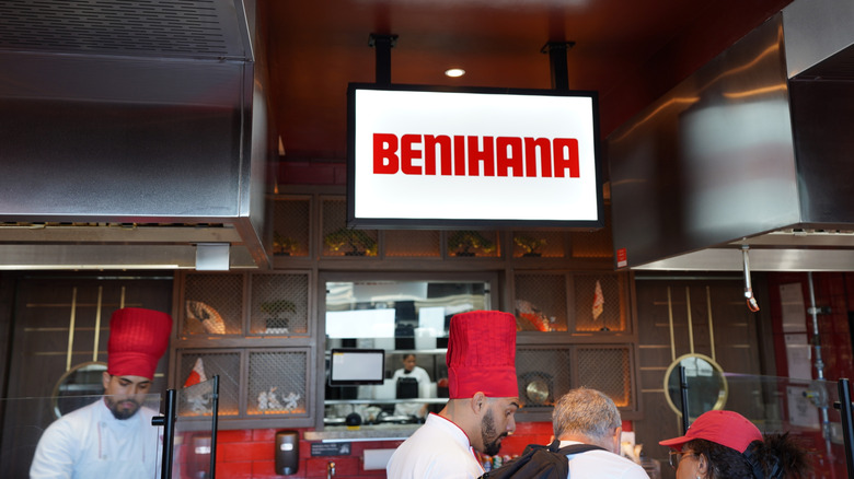 Chefs in large red hats seen working in a Benihana