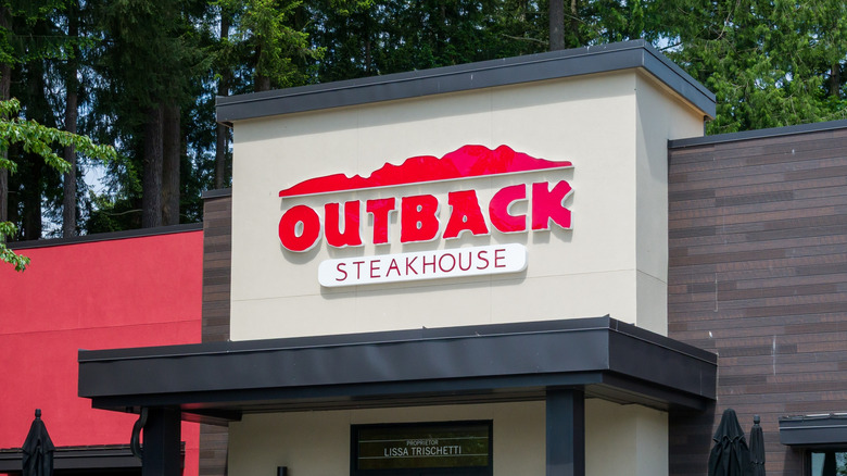 Facade of an Outback Steakhouse backed by trees