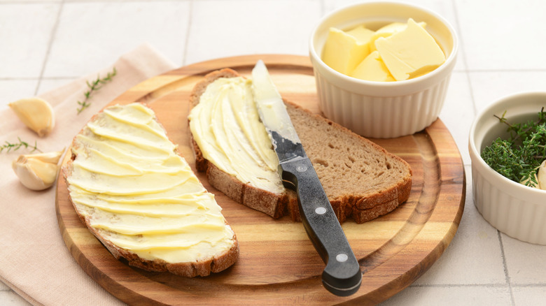 Covering bread with a garlic butter.
