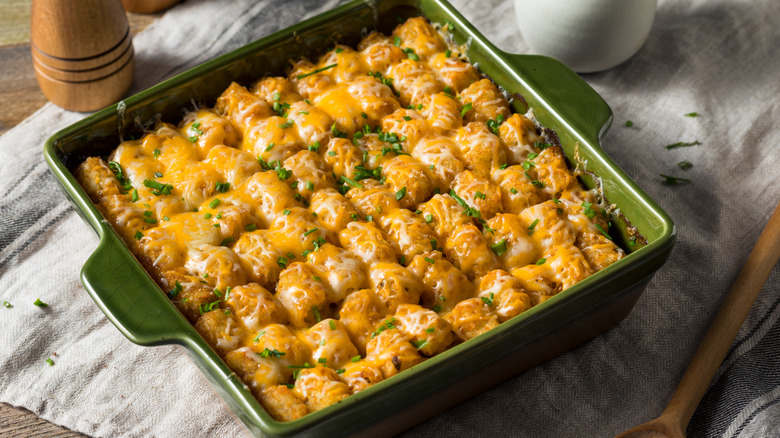 A casserole topped with tater tots, melted cheese coming through to the top