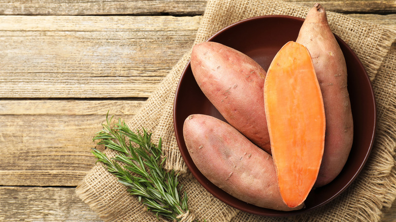 Halved and whole raw sweet potatoes.