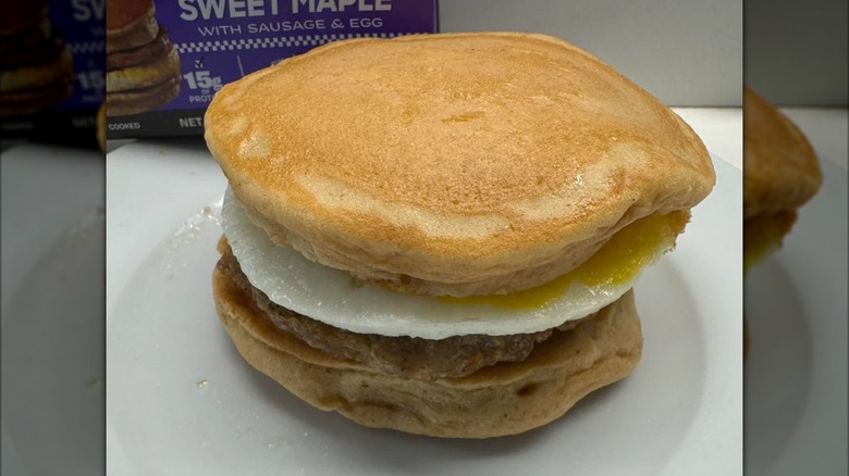 A package of Mason Dixie Pancake Sandwich box sits behind a pancake breakfast sandwich.