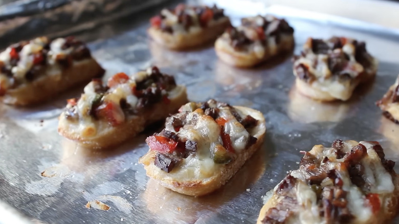 Mini Philly cheesesteaks on a baking tray.