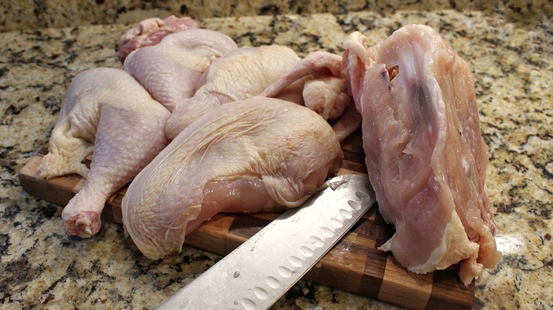 broken down whole chicken on cutting board