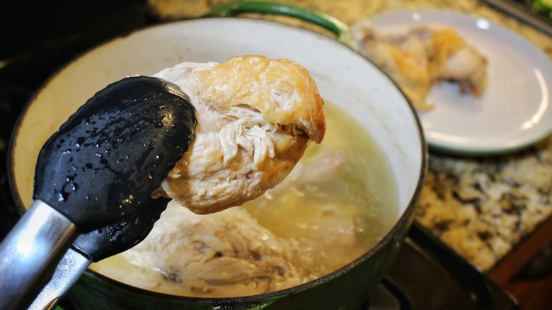 removing chicken pieces from soup pot