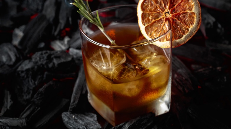 smoked iced cocktail with smoking herb garnish
