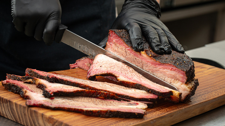 Person slicing smoked brisket