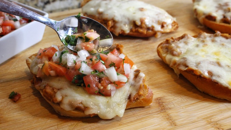 topping molletes with salsa fresca
