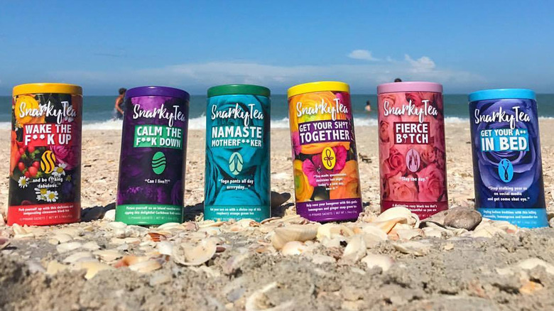 Multicolor Snarky Tea tins on the beach